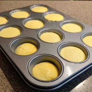 Pouring egg and cottage cheese batter into a silicone muffin pan to make egg bites