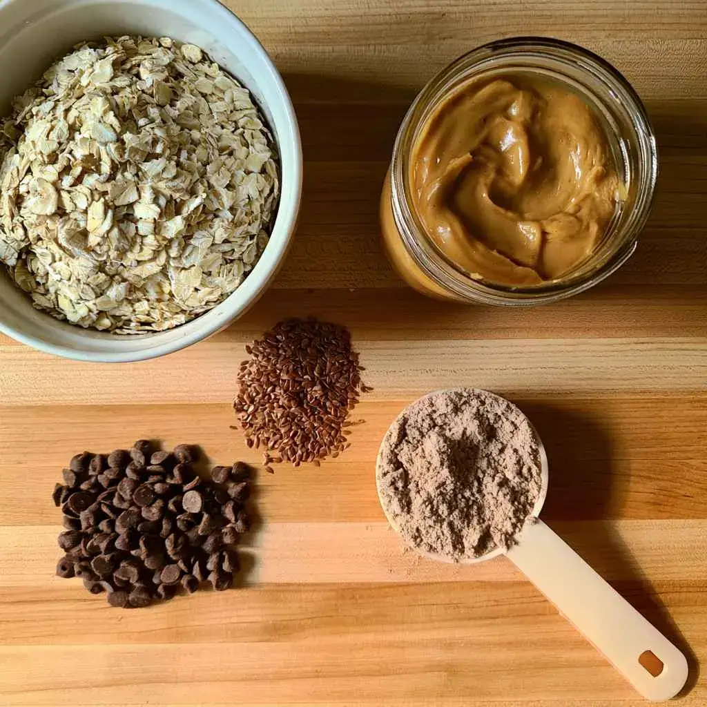 Ingredients laid out for a high protein balls recipe: oats, peanut butter, honey, flaxseed and protein powder