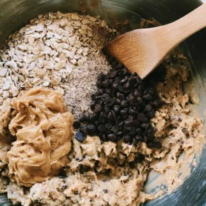 Mixing oats, peanut butter and protein powder in a bowl for a high protein balls recipe