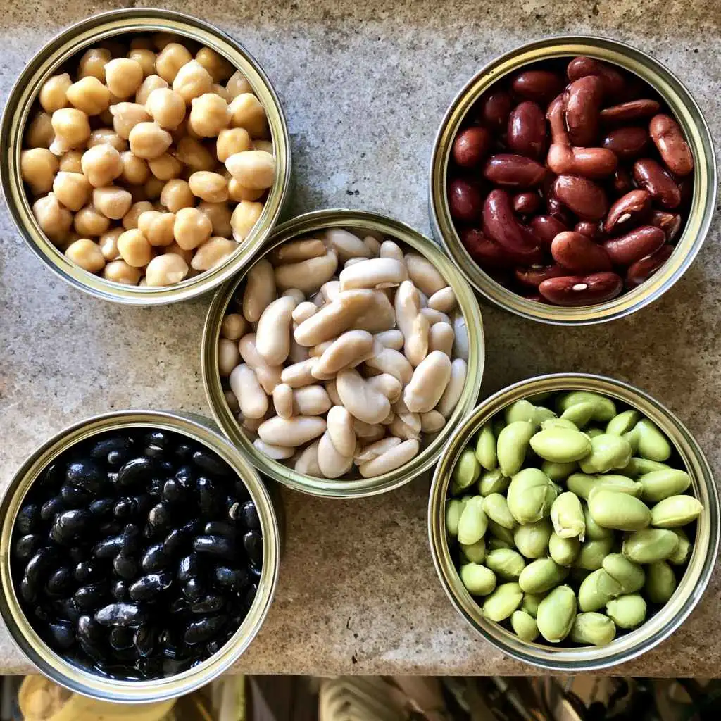 Chickpeas, cannellini beans, kidney beans, black beans and edamame in bowls for high protein bean salad