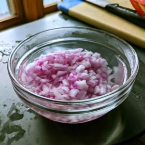 Diced red onion soaking in cold water for high protein bean salad