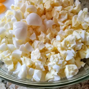Chopped hard-boiled eggs and egg whites in a glass bowl for high protein egg salad