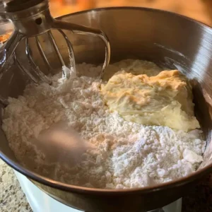 Flour and protein powder mixed into a soft high protein english muffin dough in a stand mixer