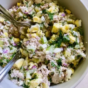 Folding egg, celery, onion, and pickle into high protein tuna salad