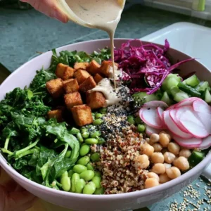 Assembling a high protein vegan salad and drizzling tahini dressing over the top