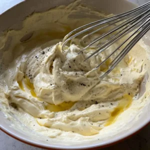 Stirring Greek yogurt, Dijon and lemon into a creamy base for tuna salad with greek yogurt