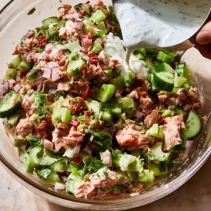 Adding diced celery, red onion and dill to flaked tuna for tuna salad with greek yogurt