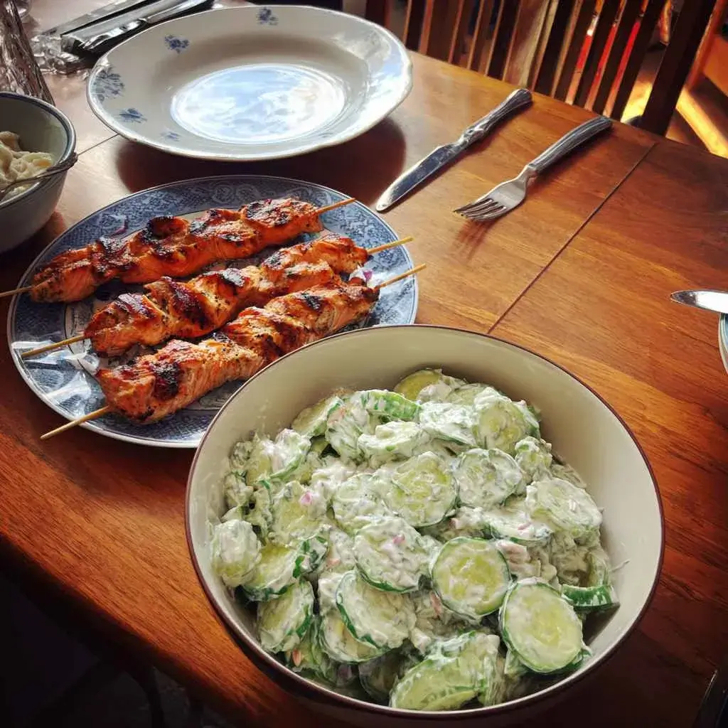 High protein cucumber salad served alongside grilled chicken and salmon as a high protein side dish